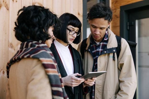A group of young professionals collaborating over a tablet for real estate planning.