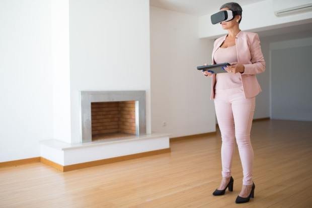 A woman explores a house interior with a VR headset in Portugal. Modern real estate technology.